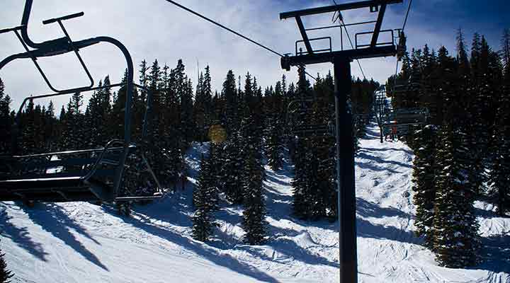 chair lifts heading up snowy mountain