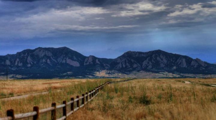 view of a fenceline with the flatirons in the background