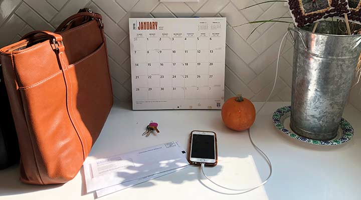 command center desk with a leather bag, calendar and cellphone charging