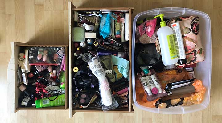 Overhead shot of three cluttered makeup drawers placed on floor