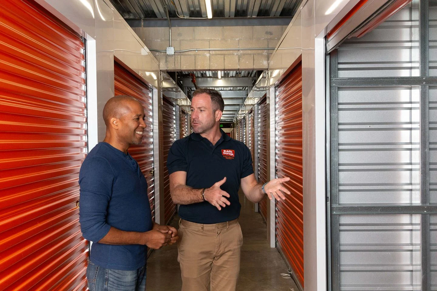 Public Storage associate giving a facility tour to a smiling customer